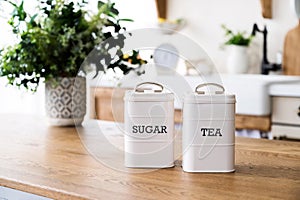 sugar and tea canisters set in retro style on wooden dining table