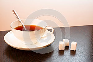 Sugar with tea in a white cup