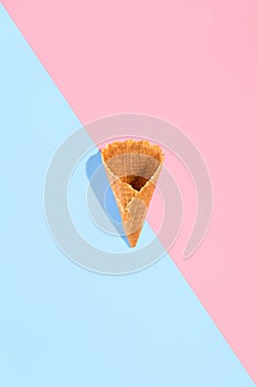 Sugar waffle cone for ice cream arranged in pattern on pink and mint background. The image with copy space can be used