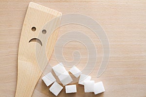 Sugar with wooden spoon on cutting board, unhealthy food additives concept