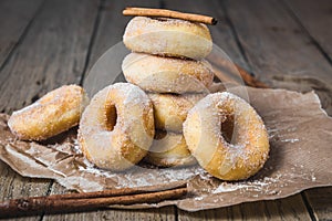 Sugared stacked mini donuts with cinnamon on a wooden table