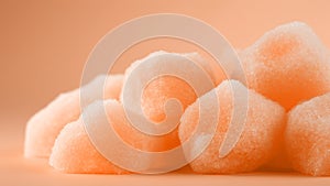 Sugary peach fuzz color jelly candies on soft minimal background. Modern trendy tone hue shade