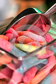Sugary sweets in a jar with a scoop. Close