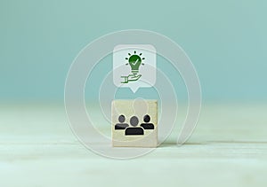 Suggestion and consulting concept. New idea, solution. Wooden cubes with holding light bulb and teamwork icon on grey background a