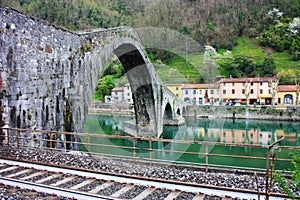 The suggestive and famous Ponte del Diavolo of Lucca built in bricks over a river in an ancient medieval village in Borgo a