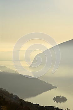 An suggestive view of Lake Iseo at sunset with the fog