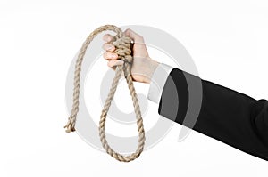 Suicide and business topic: Hand of a businessman in a black jacket holding a loop of rope for hanging on white isolated