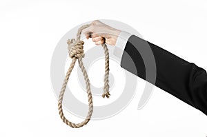 Suicide and business topic: Hand of a businessman in a black jacket holding a loop of rope for hanging on white isolated