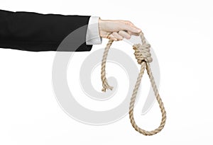 Suicide and business topic: Hand of a businessman in a black jacket holding a loop of rope for hanging on white isolated