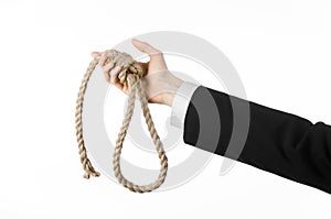 Suicide and business topic: Hand of a businessman in a black jacket holding a loop of rope for hanging on white isolated