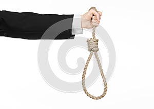 Suicide and business topic: Hand of a businessman in a black jacket holding a loop of rope for hanging on white isolated