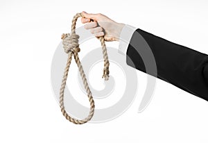 Suicide and business topic: Hand of a businessman in a black jacket holding a loop of rope for hanging on white isolated