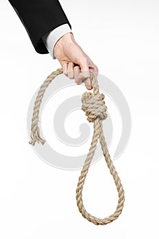 Suicide and business topic: Hand of a businessman in a black jacket holding a loop of rope for hanging on white isolated