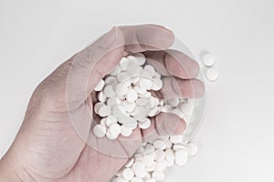 Suicide Pills,  Pills, tablets in dead man`s hand by overdosing on medication. Top view close up of overdose pills on white backgr