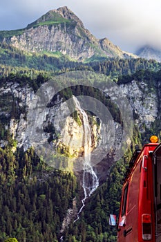 Suisse waterfall behind red firetruck vanlife camper