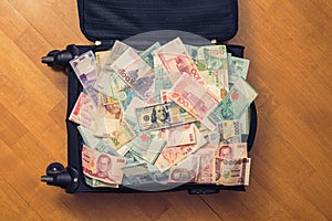 Suitcase full money of south-east Asia and American hundred dollar bill. Currency of Hong Kong, Indonesia, Malaysia, Thai, Singapo