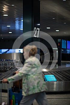Suitcase going around on the conveyor belt at an international airport, at the baggage claim zone -