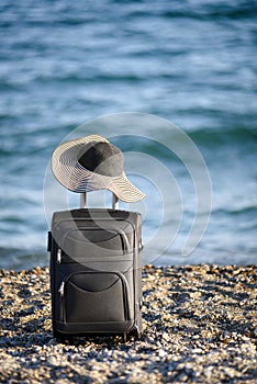 Suitcase and hat on beach