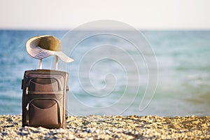 Suitcase and hat on beach