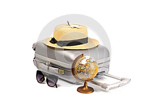 Suitcase isolated on white. Suitcase, sunglasses with toy plane, straw hat and globe in travel composition isolated on