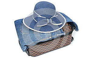 Suitcase, jean and hat on white background, concept of travel