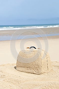 Suitcase made out of sand on beach