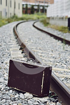 Suitcase next to the railroad tracks