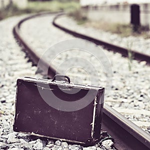 Suitcase next to the railroad tracks