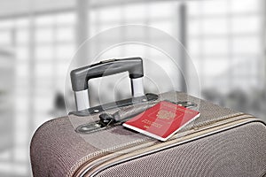 Suitcase with passport in the airport terminal. Blurred background. Adventure and travel concept