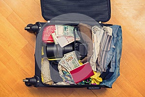 Suitcase with things and a foreign passport. Asian money and hundred-dollar bills for travel. Concept