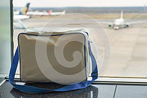 Suitcases in airport departure lounge, airplane in background, summer vacation concept, traveler suitcases in airport terminal