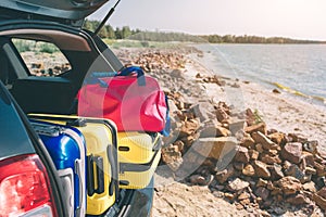 Suitcases and bags in trunk of car ready to depart for holidays. Moving boxes and suitcases in trunk of car, outdoors