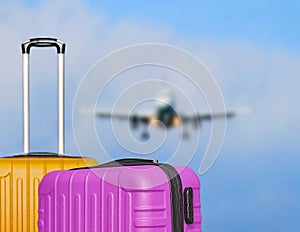 Suitcases and the blure boarding plane in the blue sky.