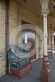 Suitcases stacked in an old railway station