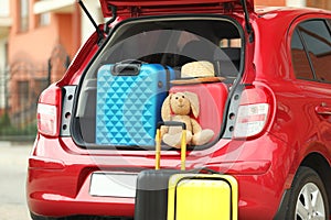 Suitcases, toy and hat in car trunk