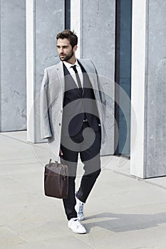 Suited businessman with coat and case