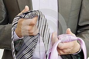 Suited man choosing ties