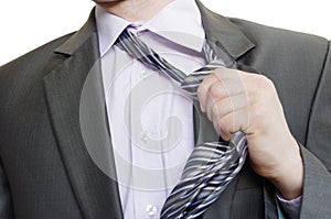 Suited man tearing off his tie on white background