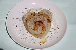 Suji Halwa or sheera, Indian sweet dish. Semolina dessert served in preety heart shape cake photo