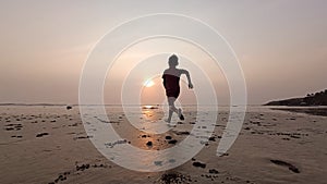 Sukabumi October 10 2023, a small Asian child is running on the beach towards the beautiful sparkling sunset