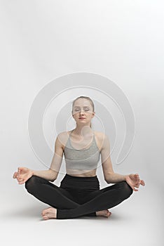 Sukhasana. Easy Pose. Young slender woman does yoga and meditates. Girl practices pranayama