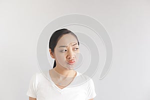 Sulk and grumpy face expression of woman in white t-shirt. Concept of offended peevish and sulky photo