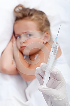 Sulking little girl receiving injection