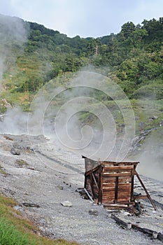 Sulphurous mountain valley with hot spring stream and steam at Tamagawa Onsen Hot spring in Senboku city, Akita prefecture, Japan