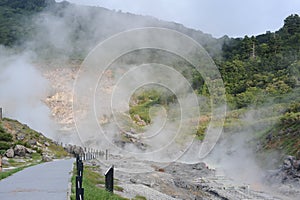 Sulphurous mountain valley with hot spring stream and steam at Tamagawa Onsen Hot spring in Senboku city, Akita prefecture, Japan