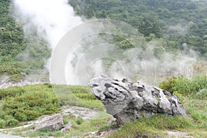 Sulphurous mountain valley with hot spring stream and steam at Tamagawa Onsen Hot spring in Senboku city, Akita prefecture, Tohoku