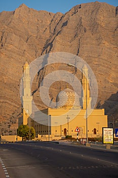 Sultan Qaboos Mosque in Bukha, Musandam, Oman at sunset with the beautiful mountains and blue sky in background