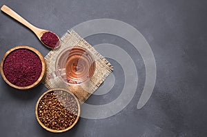 Sumac water or tea and dried ground red Sumac spices in wooden spoon with sumac berries on rustic table