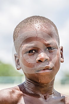 View of a portrait of African boy, child with expressive look on his wet face and deep suffering eyes