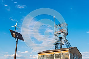 Summary of new and old technologies of energy production. Street lamp with a photovoltaic panel, a windmill and an old mine shaft